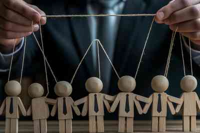 Puppenspieler im Anzug mit Holzpuppen - © Andres Mejia - stock.adobe.com